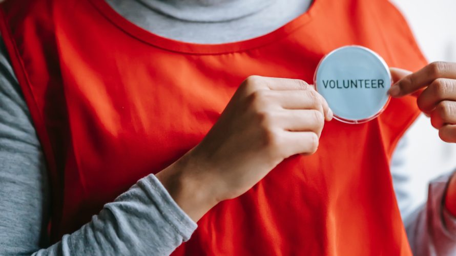 person showing a volunteer badge