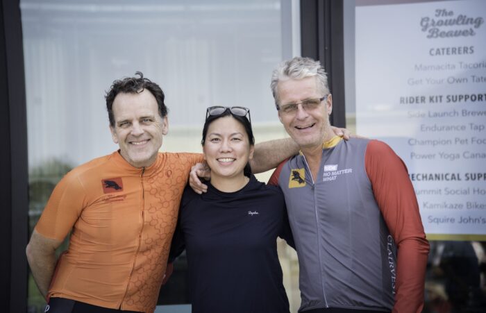 Three people standing and smiling