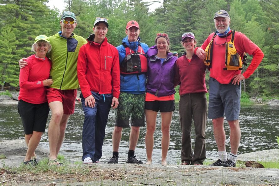 7 individuals standing on a shore