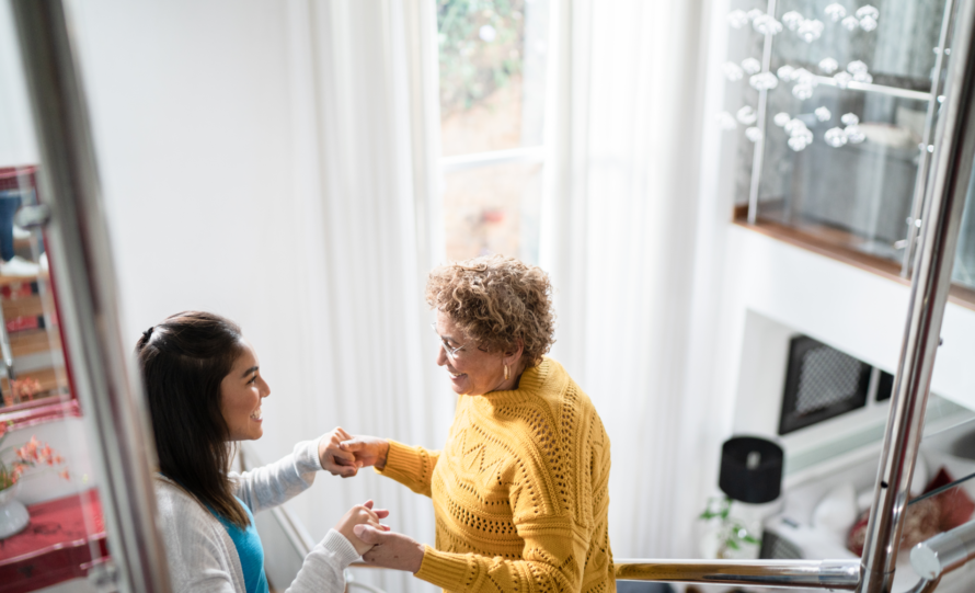 Two women smiling and holding hands