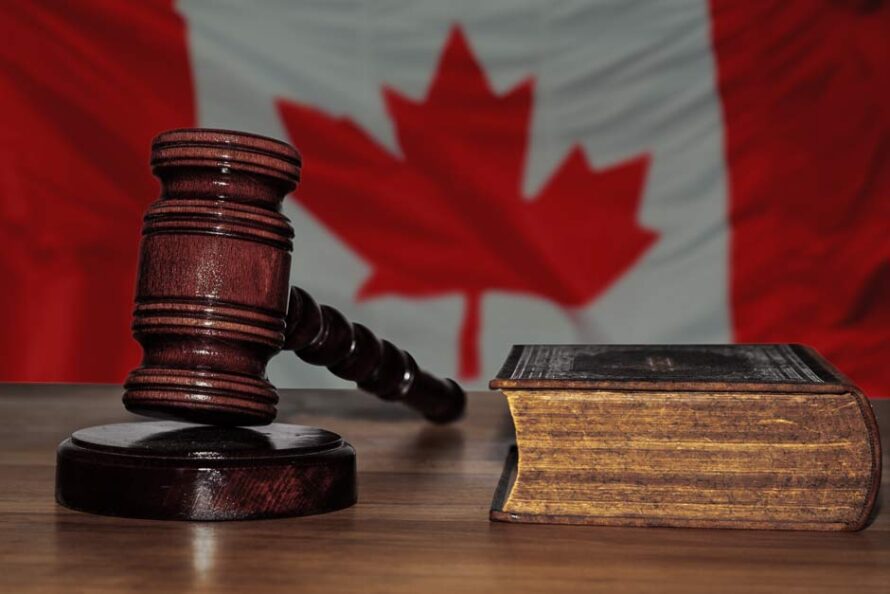 Marteau et livre de droit avec le drapeau canadien en arrière-plan