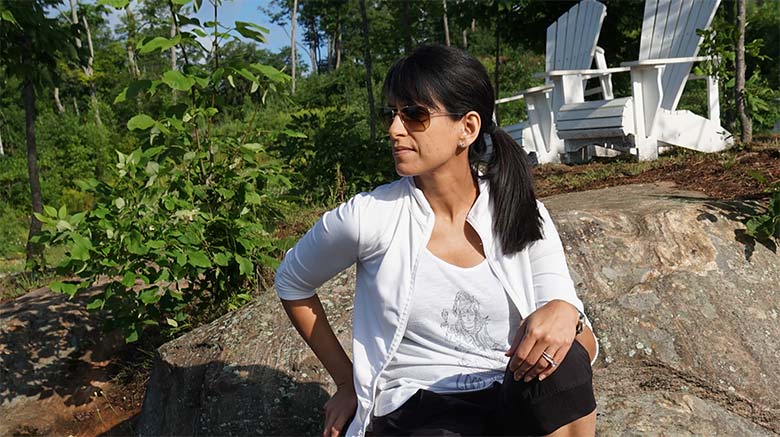 Photo de la Dre Soania Mathur assise à l'extérieur sur un gros rocher
